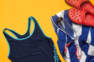 Sarı bir arka plan üzerinde düz yatıyordu yaz havuzu aksesuarları. Renkli plaj giyimi.