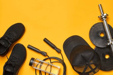 Sarı bir arka plan üzerinde bir spor salonu aksesuarları yakın çekim stüdyo çekimi. Üst görünüm, düz yatıyordu.