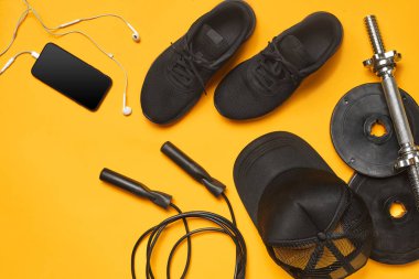 Sarı bir arka plan üzerinde bir spor salonu aksesuarları yakın çekim stüdyo çekimi. Üst görünüm, düz yatıyordu.