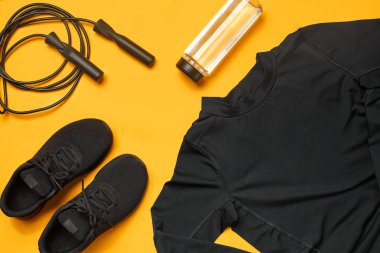 Sarı bir arka plan üzerinde bir spor salonu aksesuarları yakın çekim stüdyo çekimi. Üst görünüm, düz yatıyordu.