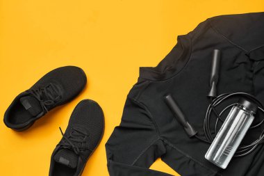 Sarı bir arka plan üzerinde bir spor salonu aksesuarları yakın çekim stüdyo çekimi. Üst görünüm, düz yatıyordu.