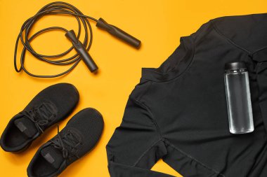 Sarı bir arka plan üzerinde bir spor salonu aksesuarları yakın çekim stüdyo çekimi. Üst görünüm, düz yatıyordu.