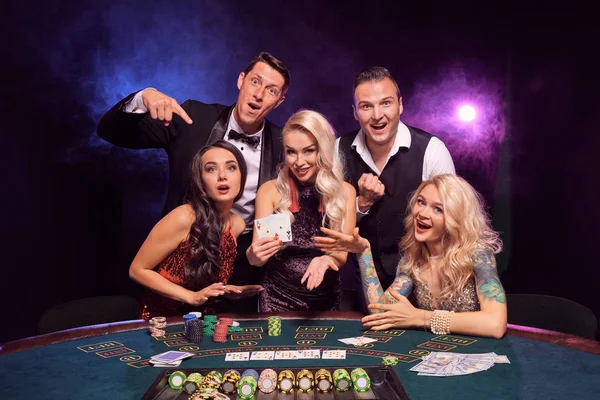 Gruppen av unge, rike venner spiller poker på et kasino . – stockfoto