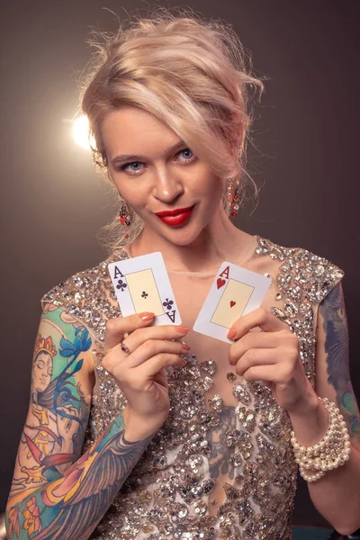 Blondine mit schöner Frisur und perfektem Make-up posiert mit Spielkarten in der Hand. Casino, Poker. — Stockfoto
