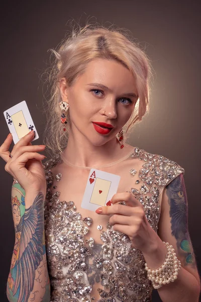 美しい髪型と完璧なメイクアップを持つブロンドの女性は、彼女の手の中にトランプでポーズをとっています。カジノ, ポーカー. — ストック写真