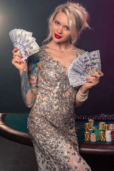 Güzel bir saç modeli ve mükemmel makyaj ile Sarışın kadın elinde biraz para ile poz veriyor. Casino, poker. — Stok fotoğraf