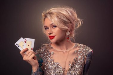 Güzel bir saç modeli ve mükemmel makyaj ile Sarışın kadın elinde iskambil kartları ile poz veriyor. Casino, poker.