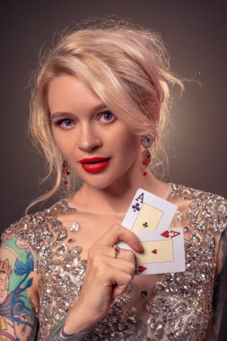Güzel bir saç modeli ve mükemmel makyaj ile Sarışın kadın elinde iskambil kartları ile poz veriyor. Casino, poker.