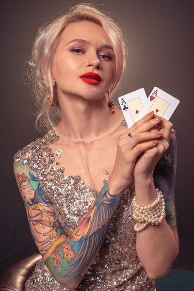 Szőke nő, gyönyörű frizura és tökéletes make-up pózol kártyákkal a kezében. Kaszinó, póker. — Stock Fotó
