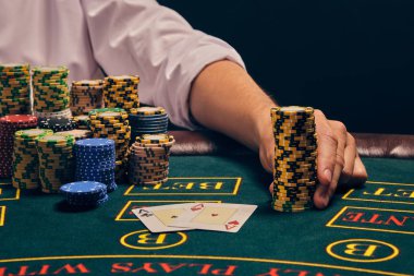Yakışıklı duygusal adam kumarhanede beyaz spot ışıklarına karşı poker oynuyor..