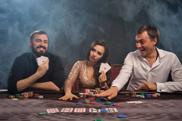 Skupina mladých bohatých přátel hrají poker v kasinu. — Stock fotografie