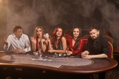 Bir grup zengin genç kumarhanede poker oynuyor..