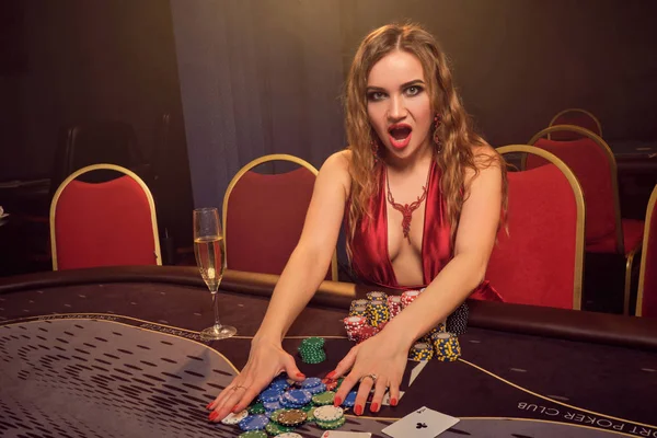 Charmig kvinna med en vacker frisyr och perfekt make-up spelar poker. Kasino. — Stockfoto