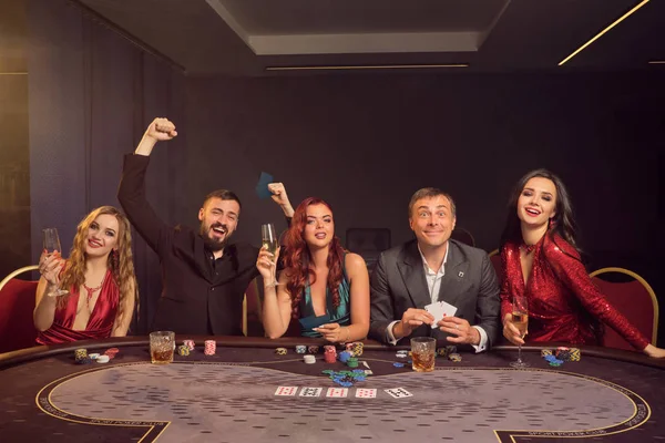 Grupo de jóvenes amigos ricos están jugando al póquer en un casino . — Foto de Stock