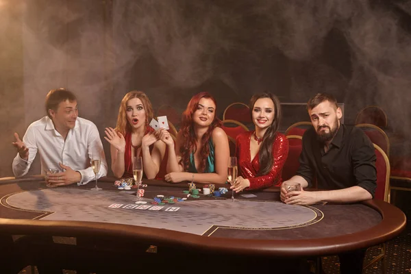 Skupina mladých bohatých přátel hrají poker v kasinu. — Stock fotografie