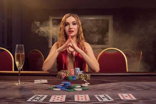 美しい髪型と完璧な化粧を持つ魅力的な女性はポーカーをプレイしています。カジノ. — ストック写真
