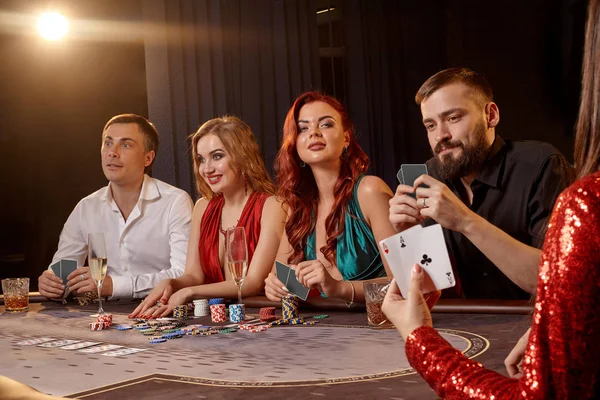 Grupo de jóvenes amigos ricos están jugando al póquer en un casino . — Foto de Stock