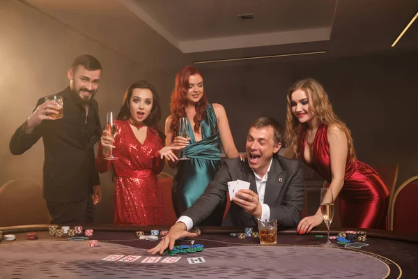 Gruppo di giovani amici ricchi stanno giocando a poker in un casinò . — Foto Stock