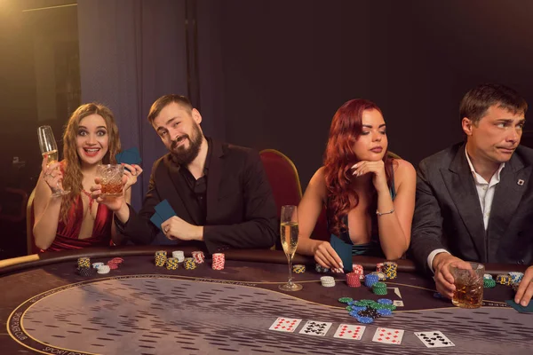 Grupp av unga rika vänner spelar poker på ett kasino. — Stockfoto
