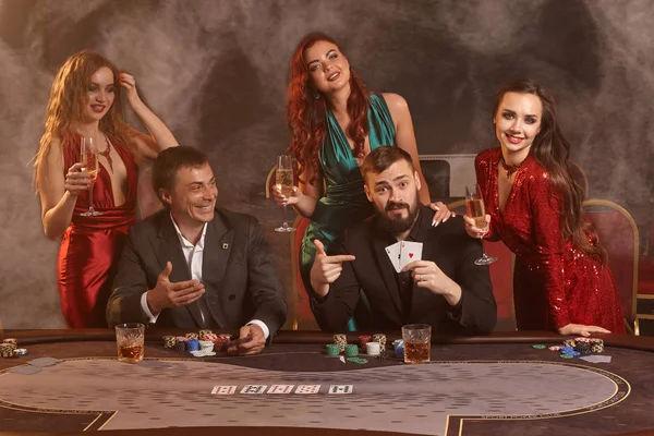 Grupo de jóvenes amigos ricos están jugando al póquer en un casino . — Foto de Stock