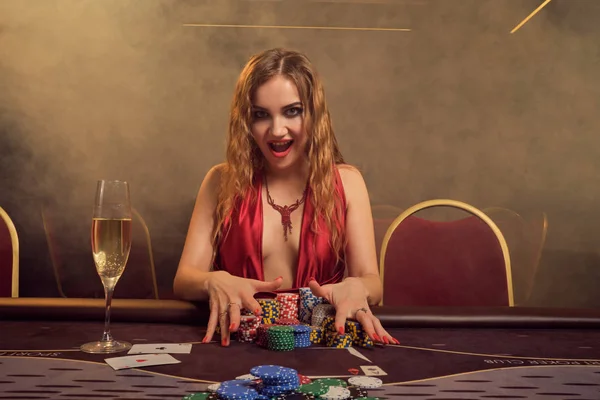 Очаровательная женщина с красивой прической и идеальным макияжем играет в покер. Казино . — стоковое фото