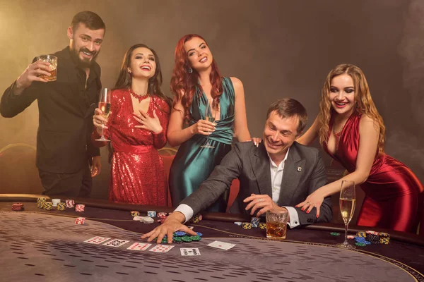 Grupo de jovens amigos ricos estão jogando poker em um cassino . — Fotografia de Stock
