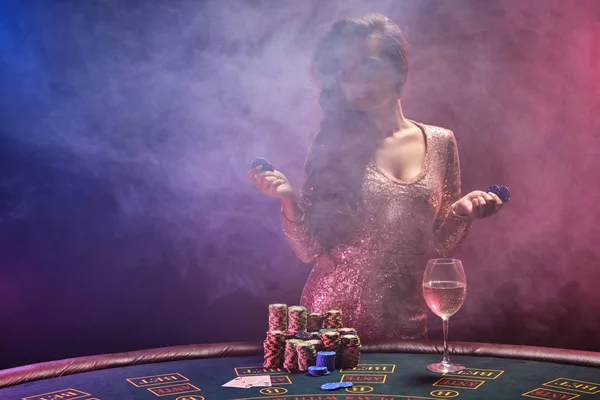 Bruneta dívka s dokonalým účesem a světlý make-up je pózování s karban žetony v rukou. Kasino, poker. — Stock fotografie