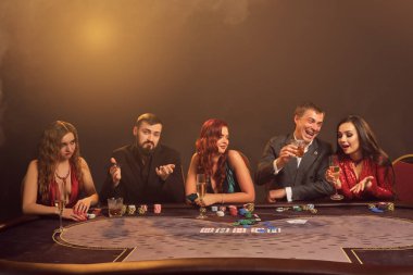 Bir grup zengin genç kumarhanede poker oynuyor..