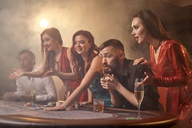 Bir grup zengin genç kumarhanede poker oynuyor..