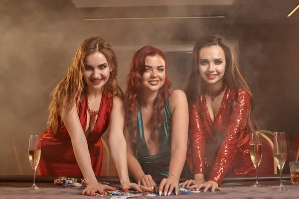 Tre belle giovani donne stanno giocando a poker in un casinò . — Foto Stock