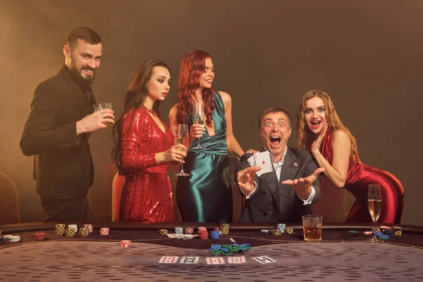 Grupo de jóvenes amigos ricos están jugando al póquer en un casino . — Foto de Stock