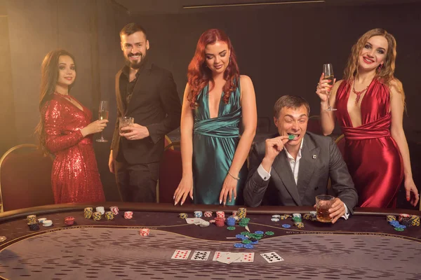 Group of a young wealthy friends are playing poker at a casino. — Stock Photo, Image