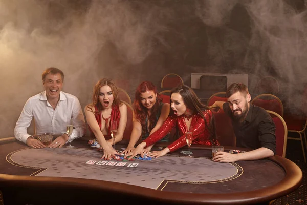 Group of a young wealthy friends are playing poker at a casino. — Stock Photo, Image