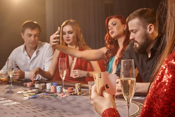 Skupina mladých bohatých přátel hrají poker v kasinu. — Stock fotografie