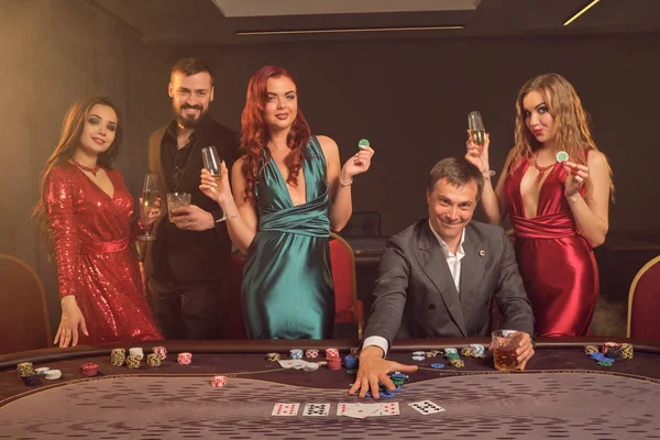 Grupo de jóvenes amigos ricos están jugando al póquer en un casino . — Foto de Stock