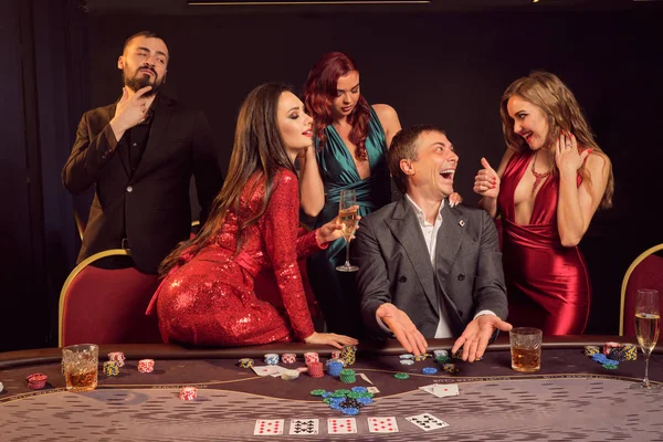 Group of a young wealthy friends are playing poker at a casino. — Stock Photo, Image