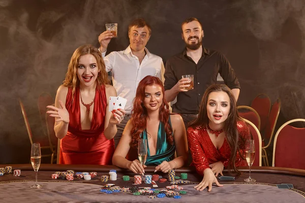 Grupo de jóvenes amigos ricos están jugando al póquer en un casino . — Foto de Stock