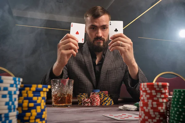 Schöner bärtiger Mann pokert am Tisch im Casino. — Stockfoto