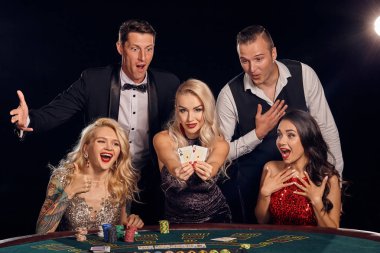 Şık ve zengin bir grup kumarhanede poker oynuyor..