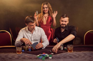 Bir grup zengin genç kumarhanede poker oynuyor..