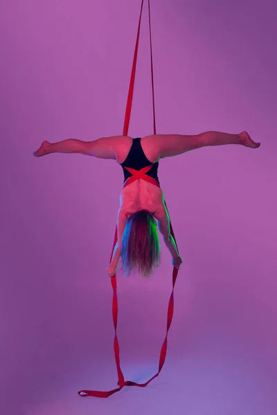 Hermosa chica en un traje de baño negro está realizando una acrobacia elementos en el estudio . —  Fotos de Stock