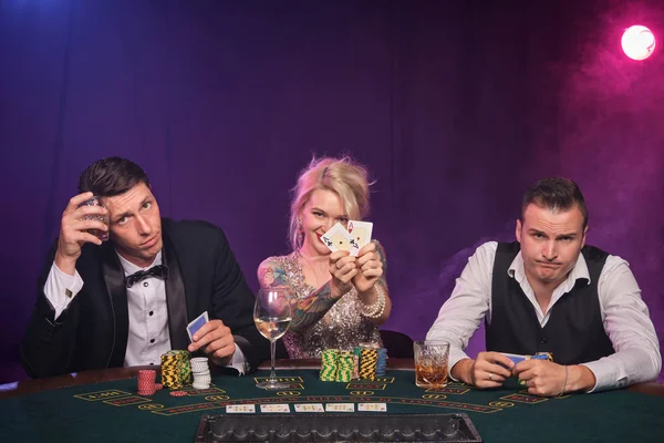 Group of a young wealthy friends are playing poker at a casino.