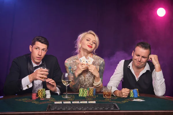 Grupo de jóvenes amigos ricos están jugando al póquer en un casino . — Foto de Stock