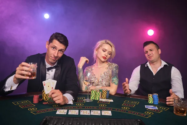 Grupo de jóvenes amigos ricos están jugando al póquer en un casino . — Foto de Stock