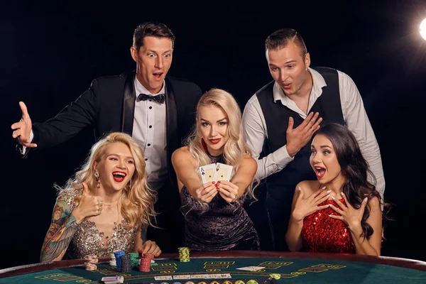 Grupo de amigos ricos con estilo están jugando póquer en un casino . — Foto de Stock