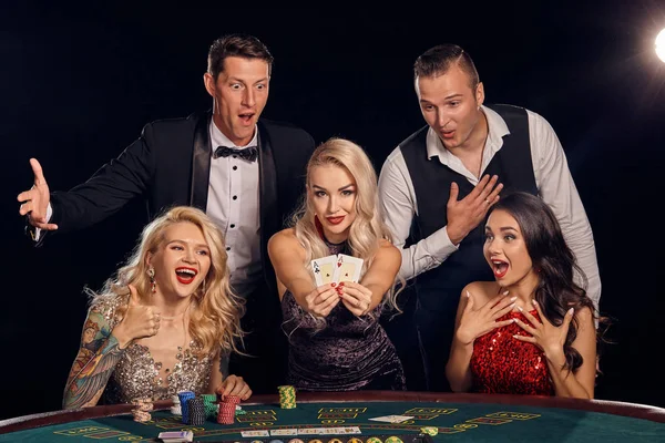Şık ve zengin bir grup kumarhanede poker oynuyor..
