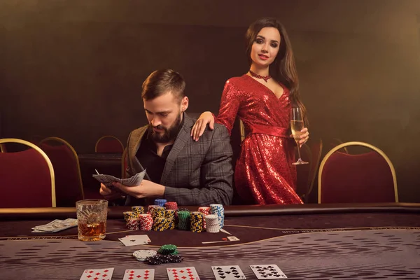 Charming wealthy couple are playing poker at a casino. — Stock Photo, Image
