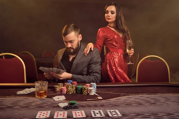 Okouzlující bohatý pár hrají poker v kasinu. — Stock fotografie