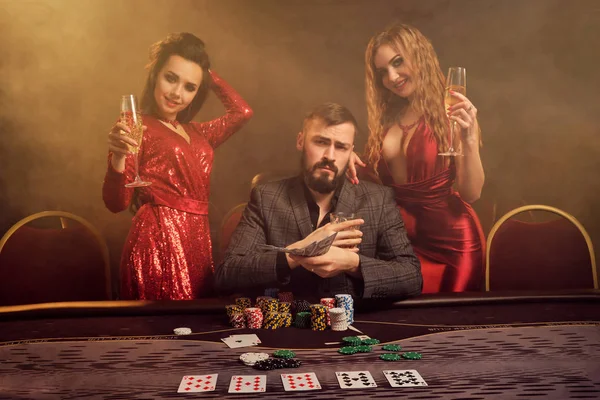 Skupina mladých bohatých přátel hrají poker v kasinu. — Stock fotografie