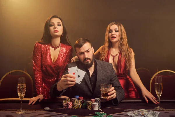 Grupo de jóvenes amigos ricos están jugando al póquer en un casino . — Foto de Stock